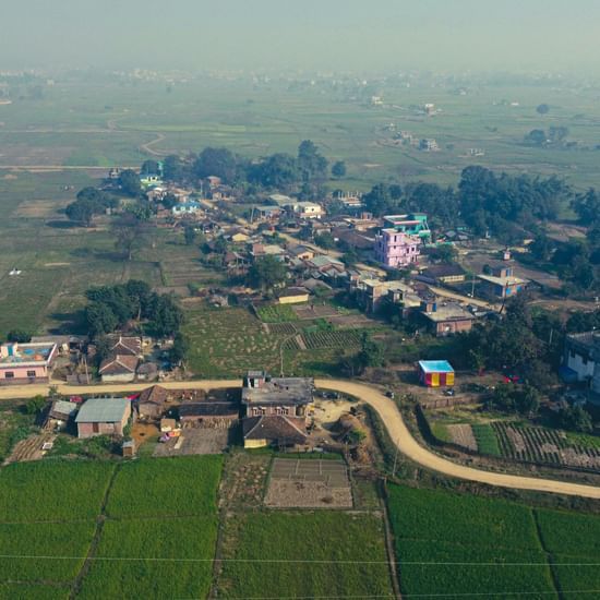 Aerial view of a modern city with highways, buildings, and greenery.