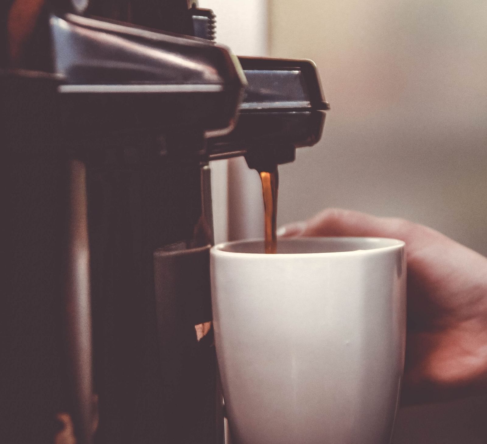 Coffee machine dispensing coffee into a white cup