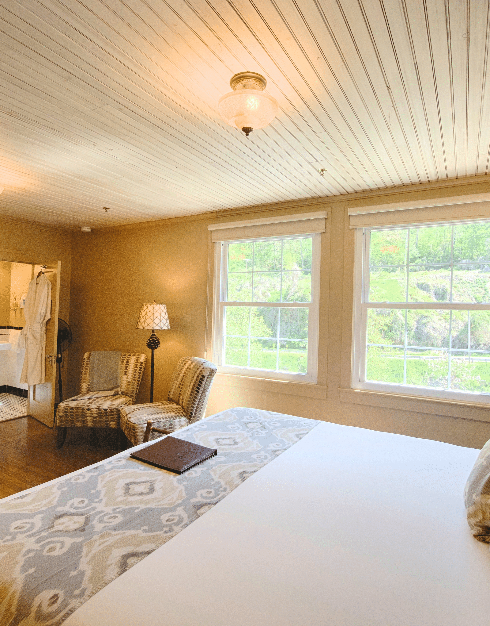 a bright bedroom with ample of natural light coming form the windows beside the double bed - Historic Tapoco Lodge