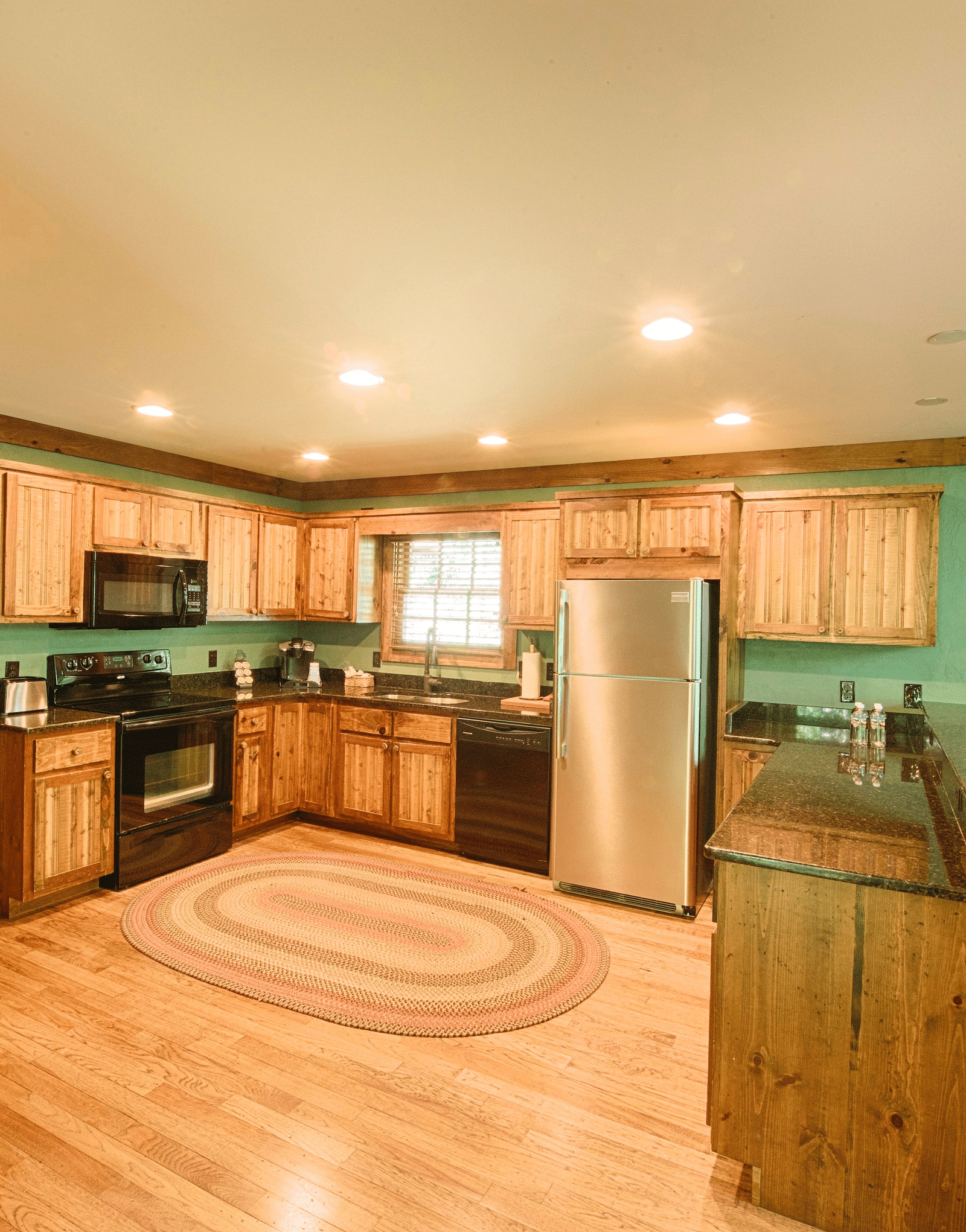 a fully-equipped kitchen with modern appliances and a service counter in the corner with elevated chairs - Historic Tapoco Lodge