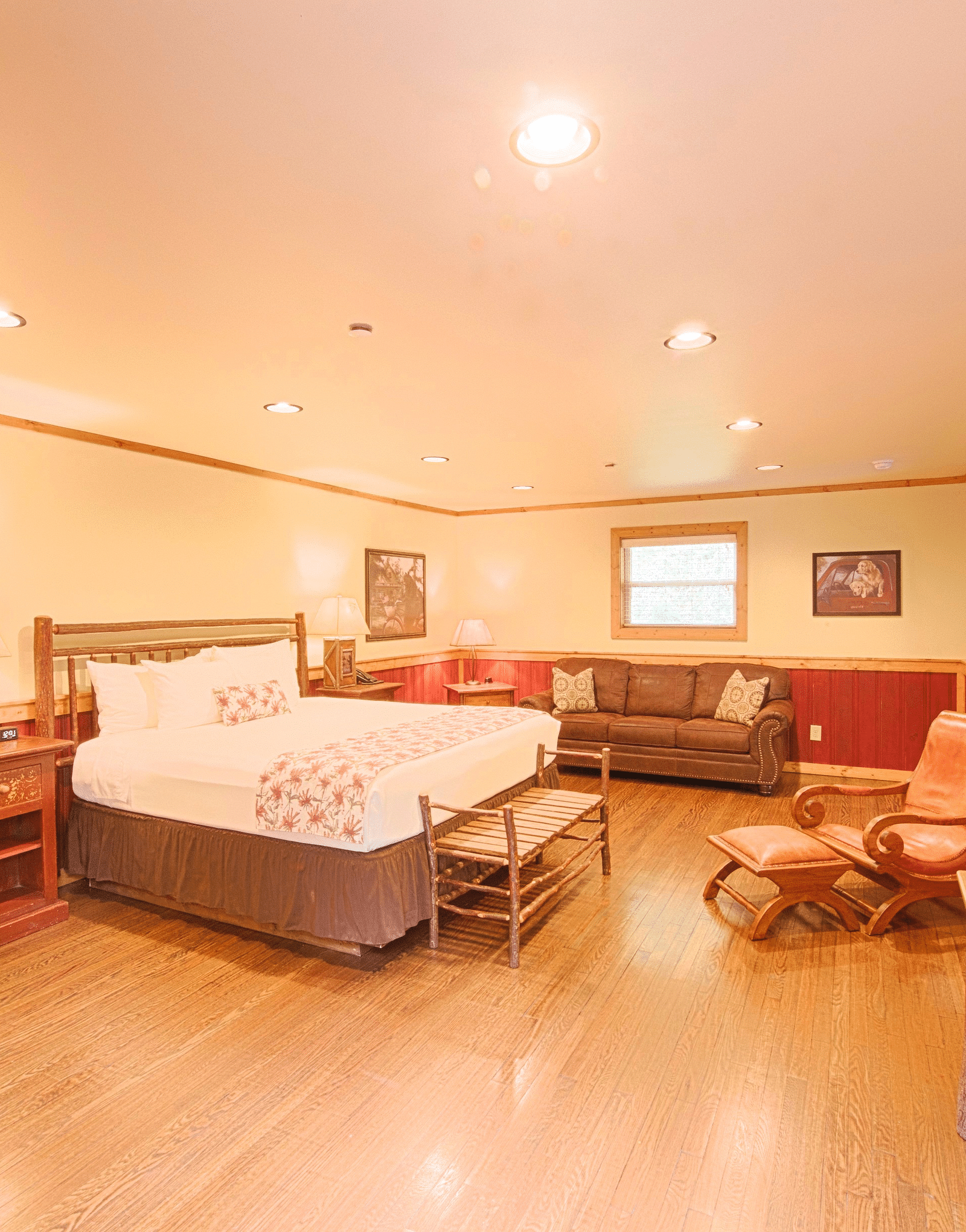 a cushioned armchair placed opposite to the double bed in the room with a closed wooden door besides it - Historic Tapoco Lodge