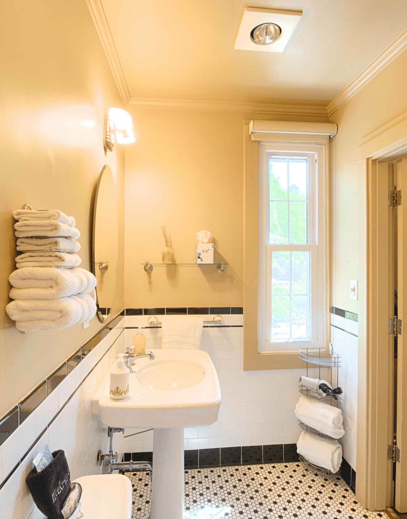 a small bathroom with a wash basin with fresh towels staked besides it - Historic Tapoco Lodge