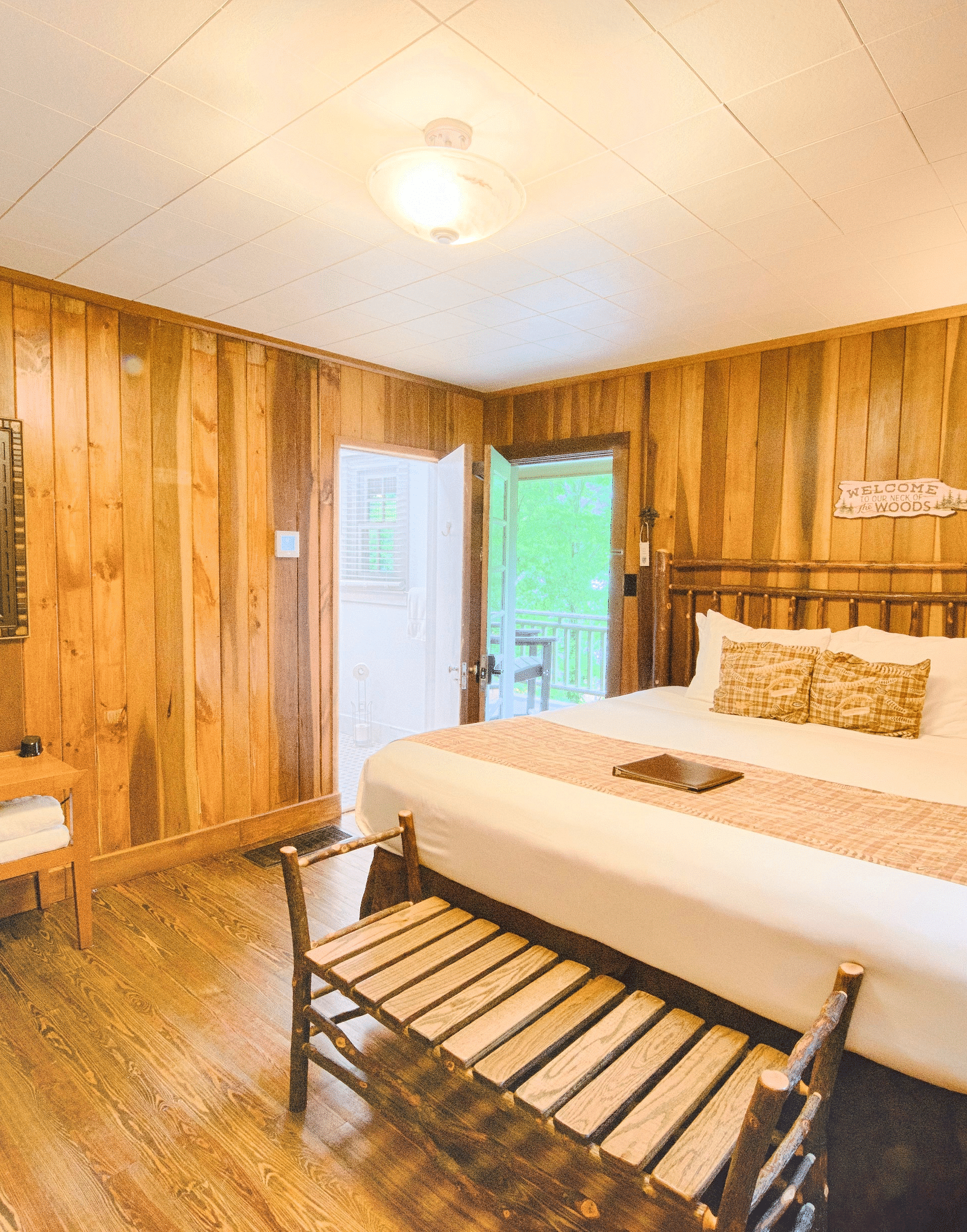 a brightly lit bedroom with the entrance door right besides the double bed with ample natural light - Historic Tapoco Lodge