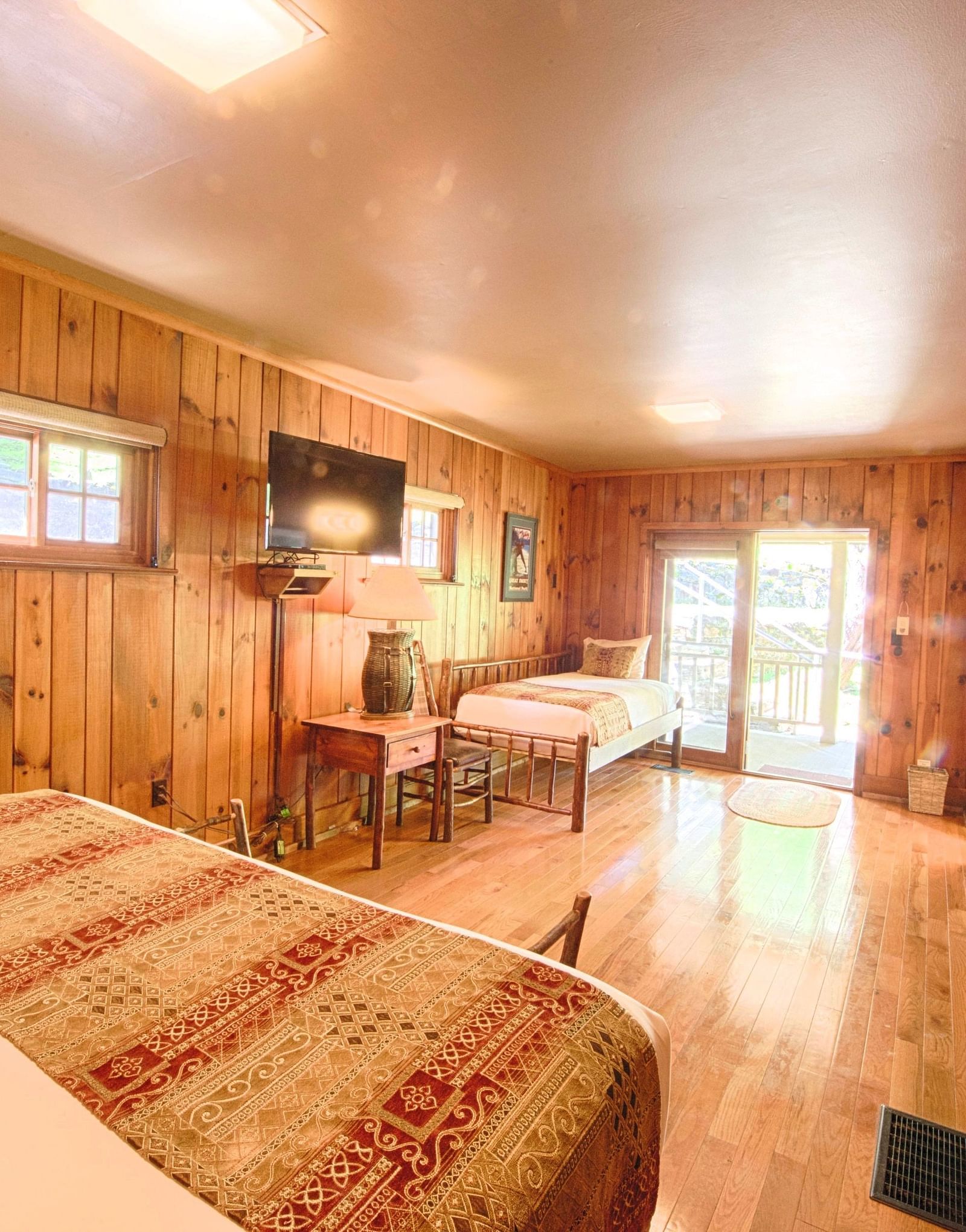 corner view of a bedroom featuring two beds along with bright natural light illuminating the room from the entrance - Historic Tapoco Lodge
