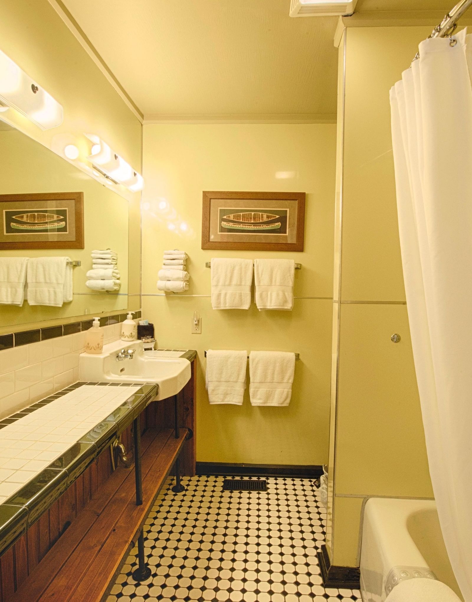 a wide angle shot of a bathroom featuring a bathtub and fresh linens hanging besides the wash basin - Historic Tapoco Lodge