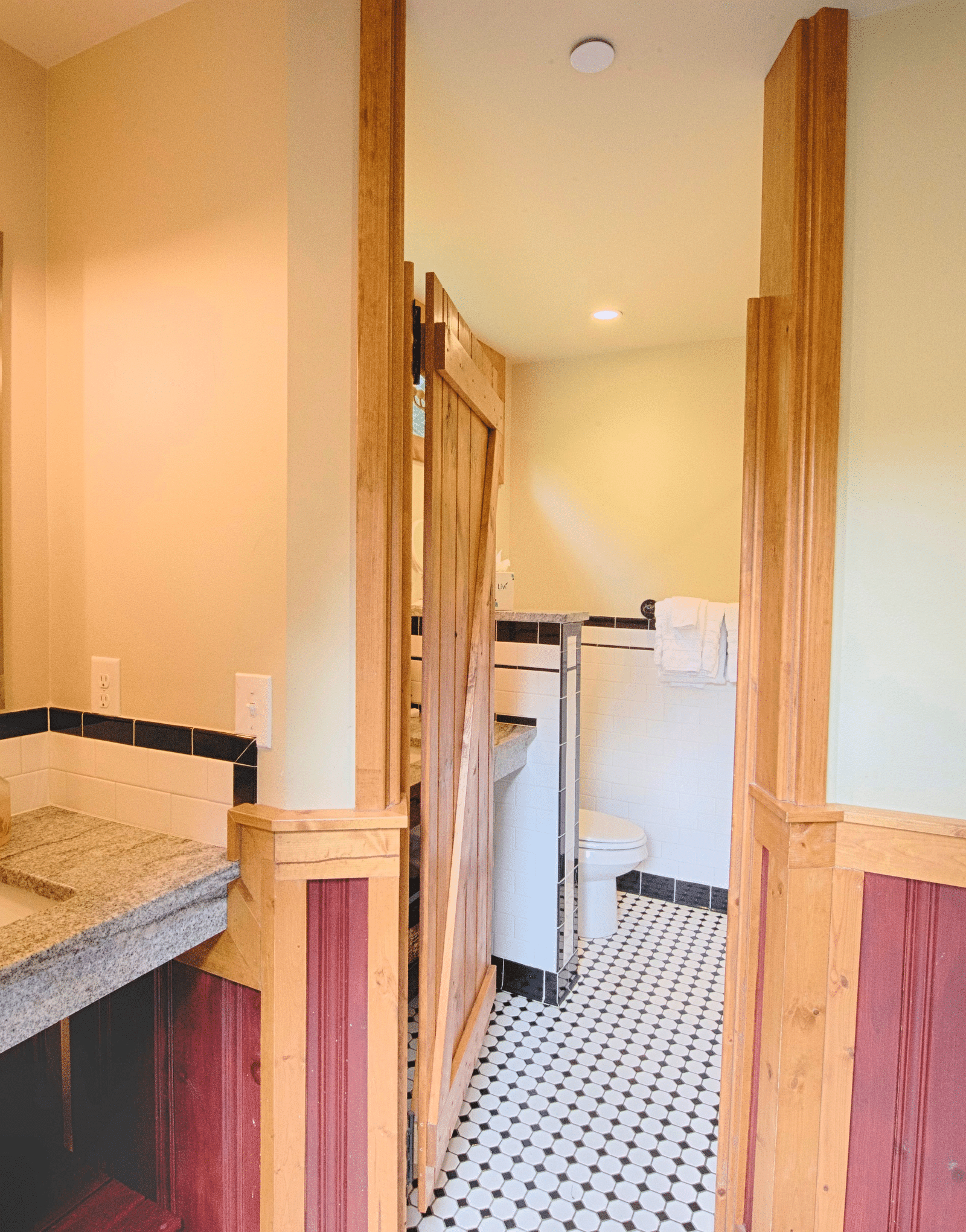 a bathroom with a wash basin and mirror along with a door leading to the commode - Historic Tapoco Lodge
