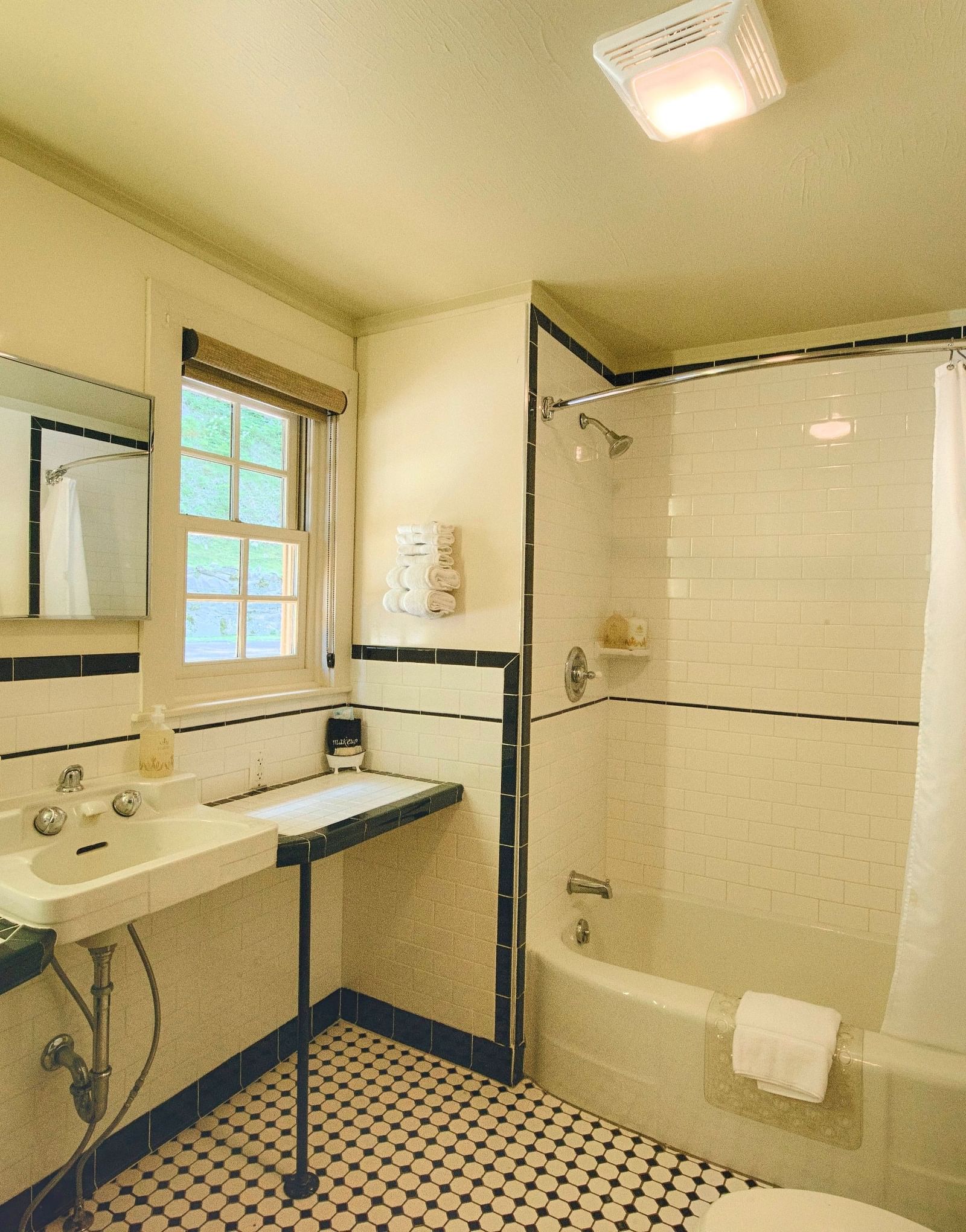 full view image of the bright bathroom with a bathtub and a wash basin - Historic Tapoco Lodge