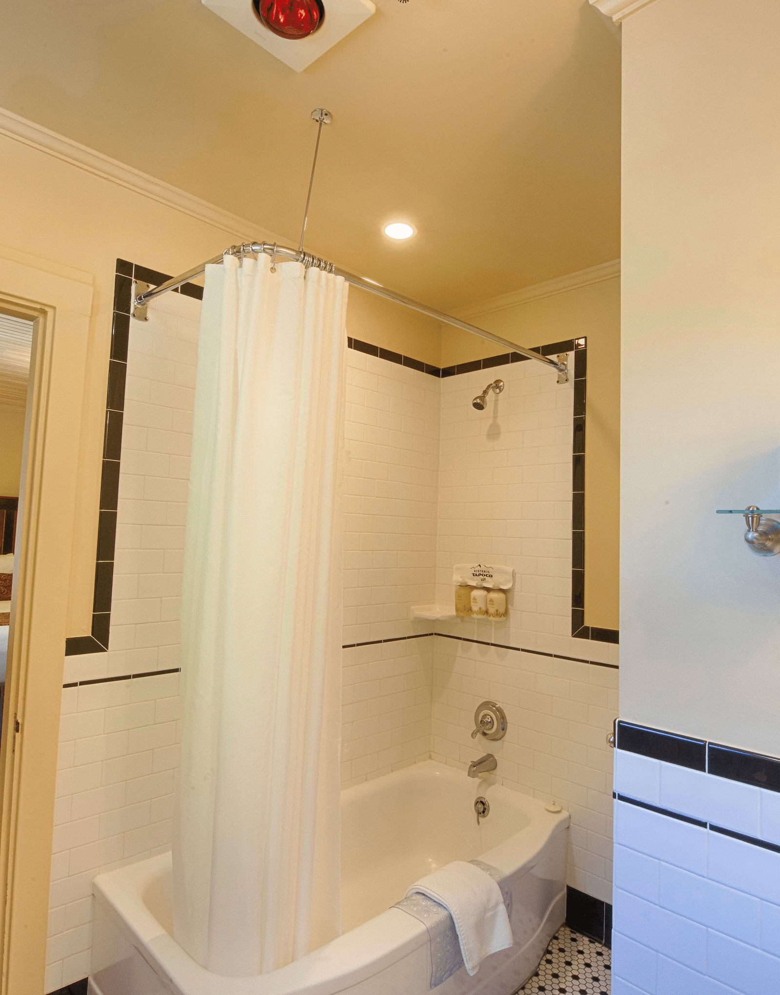 a door opening into the bathroom with a full size bath tub beside it - Historic Tapoco Lodge