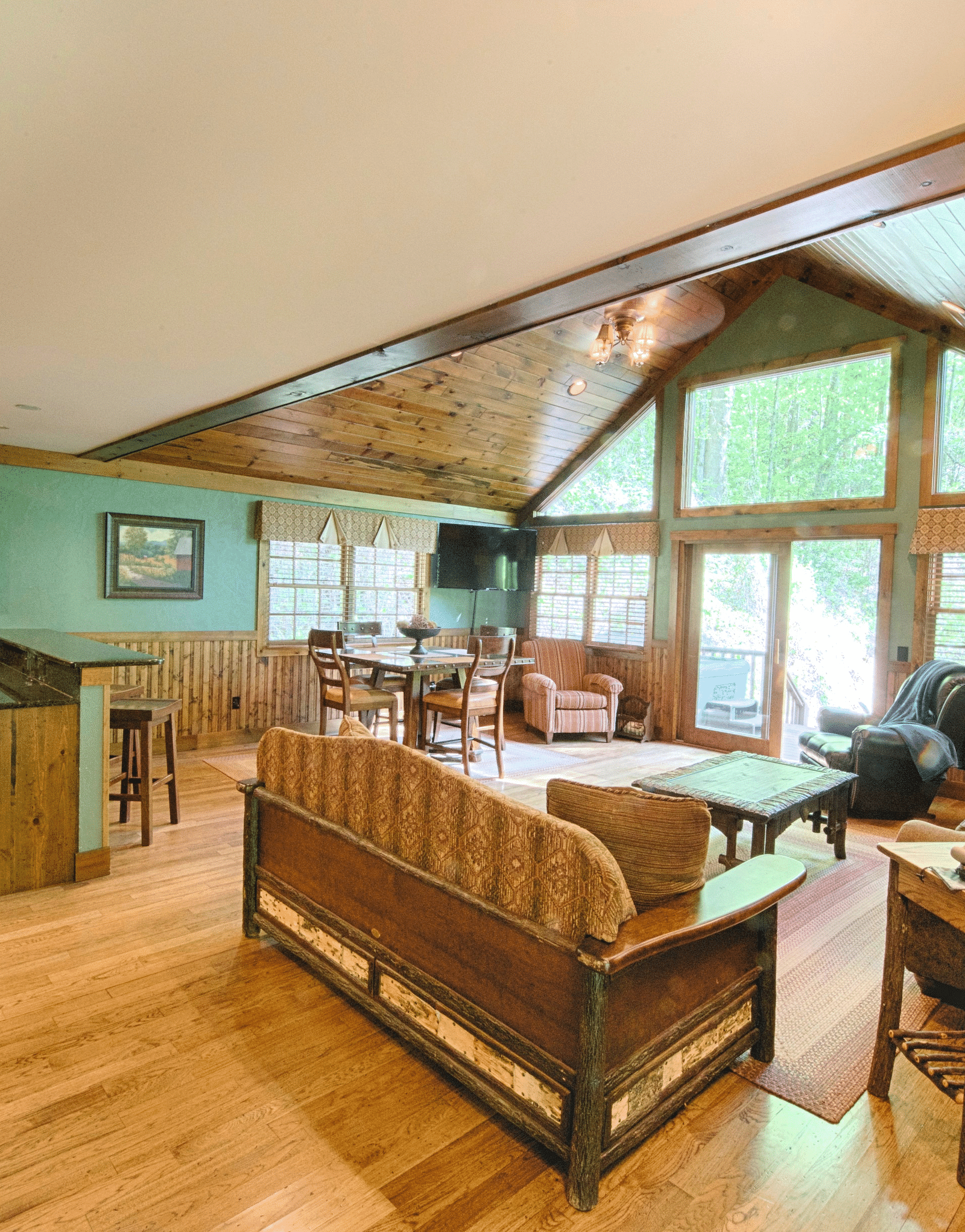 an entrance to the cabin featuring the entire living area along with a silver fridge in the corner - Historic Tapoco Lodge
