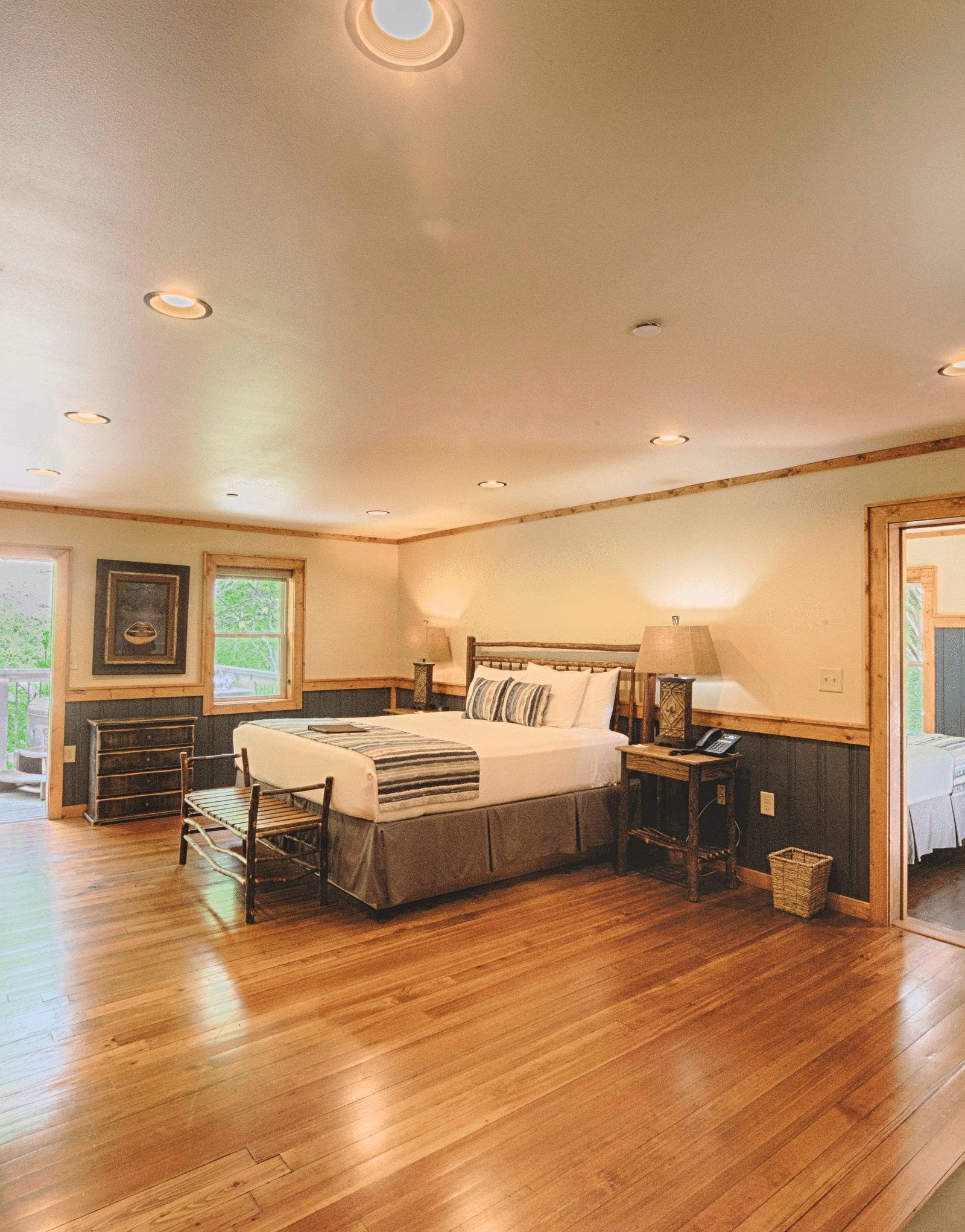 a bedroom with wooden flooring featuring a double bed in the middle - Historic Tapoco Lodge