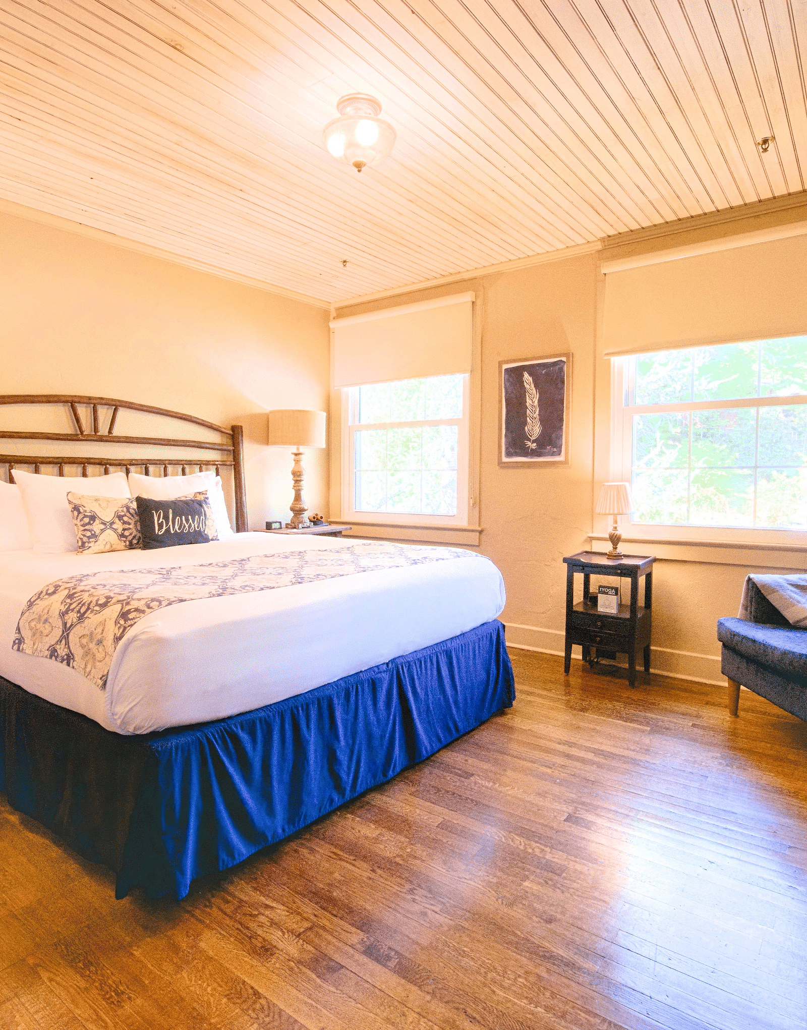 full view image of a room featuring a double bed with bed side tables along with a wooden cabinet in front of it - Historic Tapoco Lodge