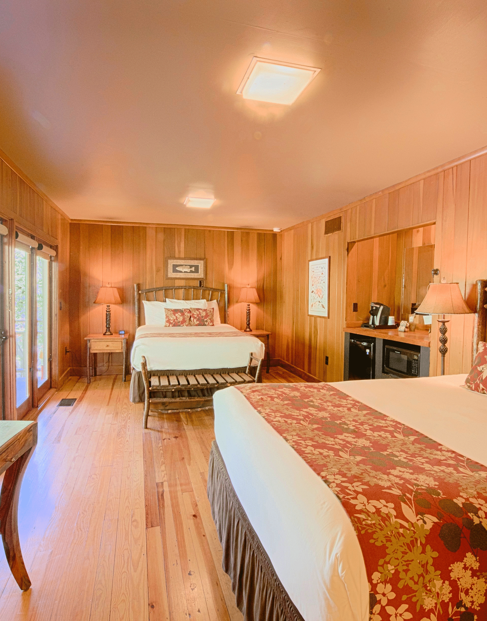a room with ample of natural light coming from the huge windows featuring two comfortable double beds - Historic Tapoco Lodge