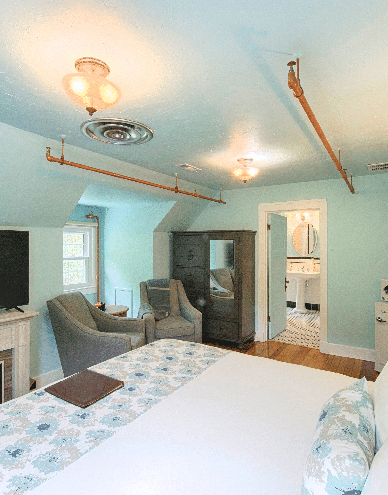 a room featuring an electric fireplace along with a flat screen television above it placed right opposite the bed - Historic Tapoco Lodge