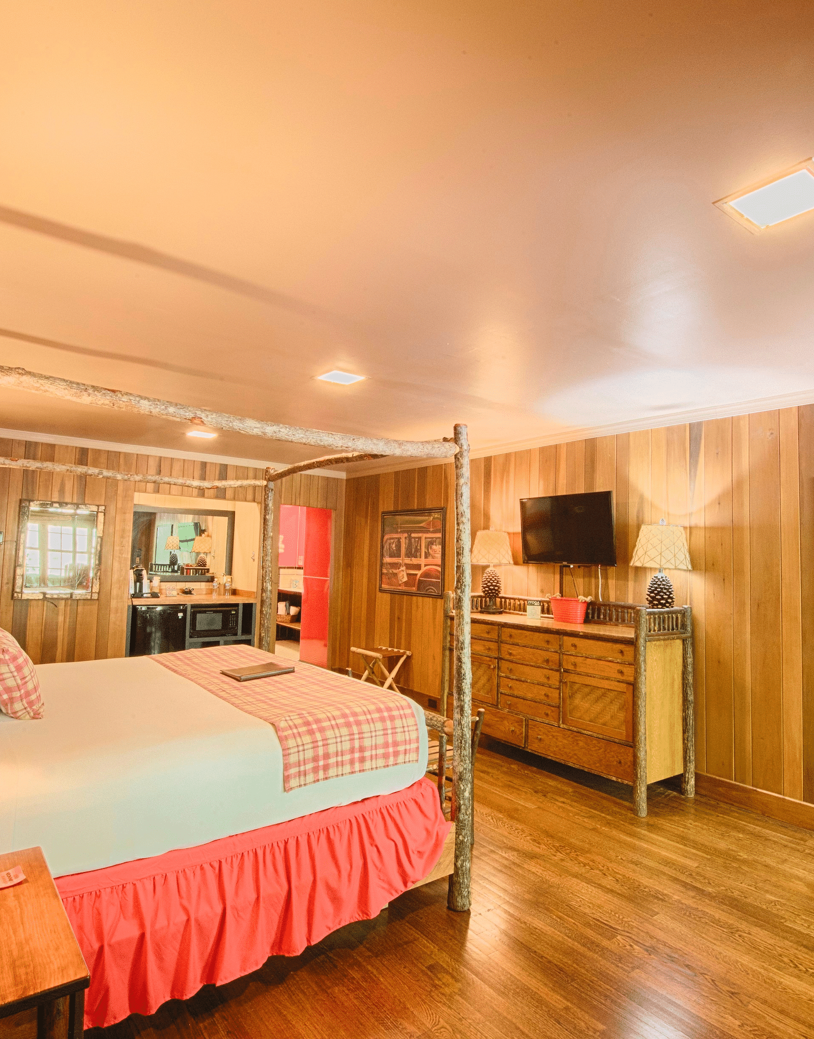 a cozy room with wooden interiors and modern amenities featuring a plush king size bed - Historic Tapoco Lodge