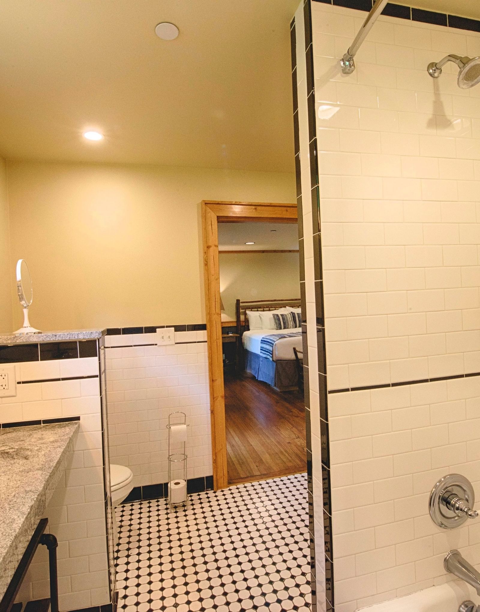 a bathroom with a bath tub along with a standing shower and a huge mirror right opposite to it - Historic Tapoco Lodge
