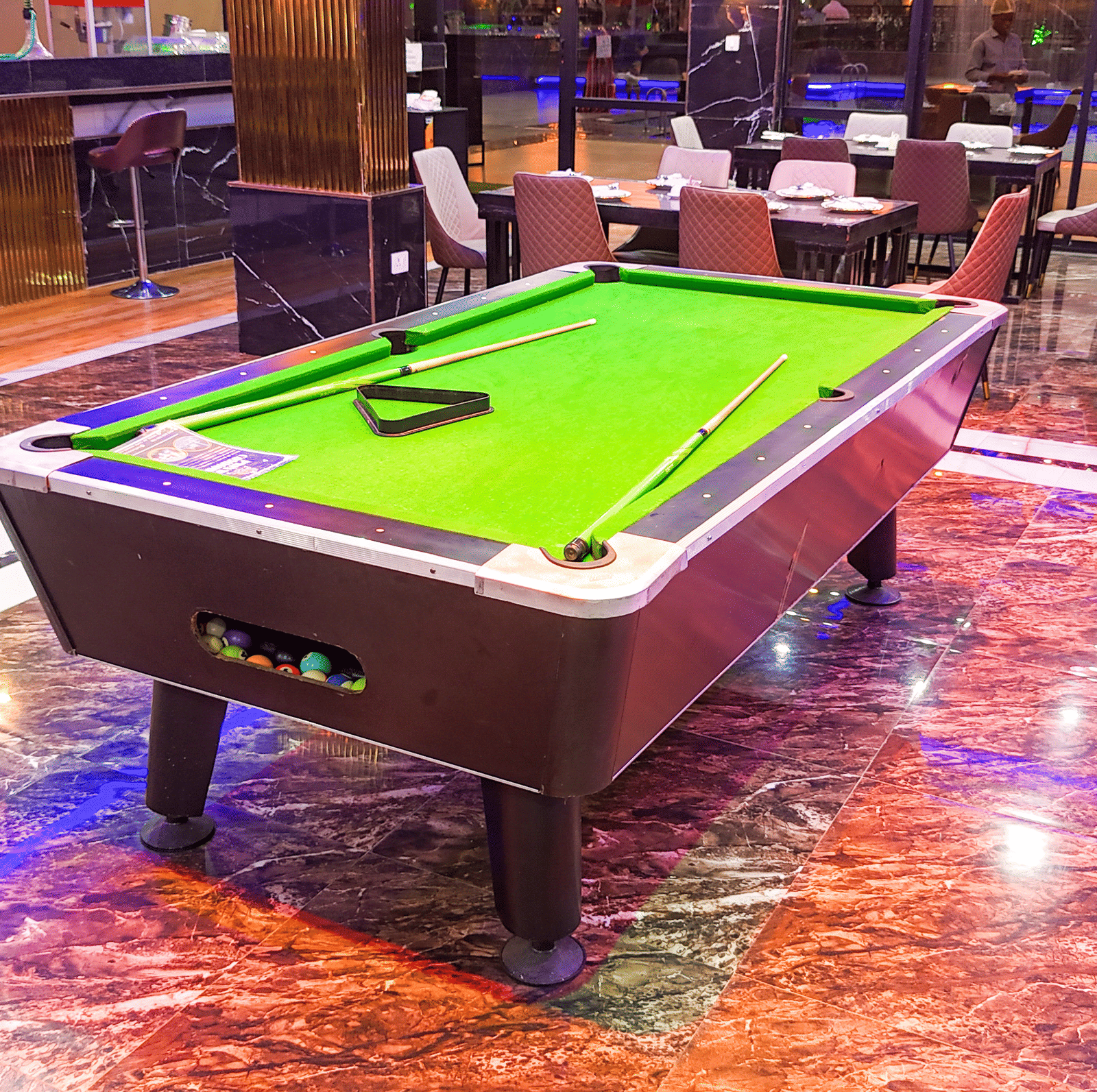 Interior view of a lounge area with a small pool table - Luffu Club