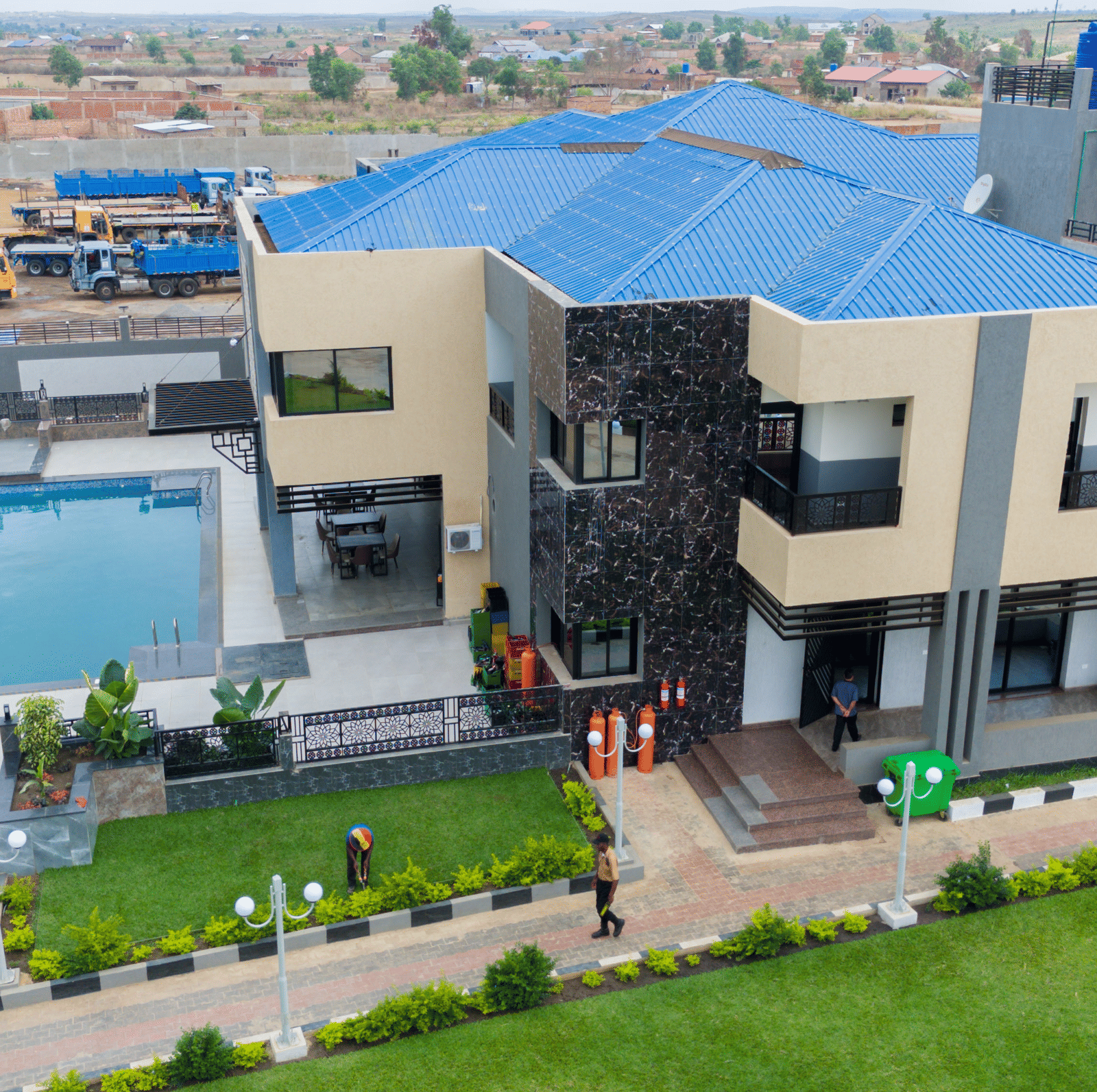 Aerial view of a large modern building with a swimming pool and well-maintained grounds - Luffu Club