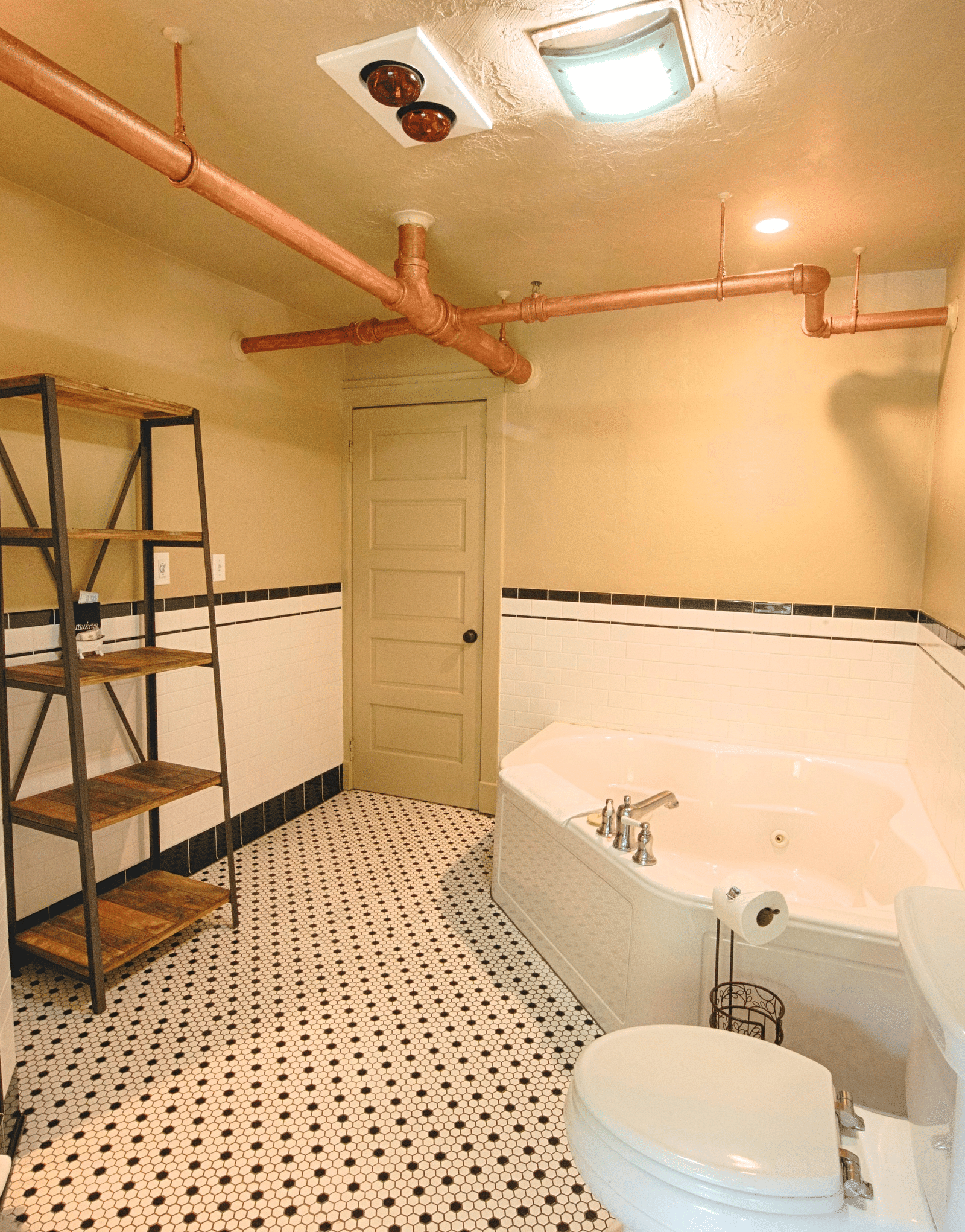 corner view image of the bathroom featuring a commode and a bathtub with towels towed above the toilet - Historic Tapoco Lodge