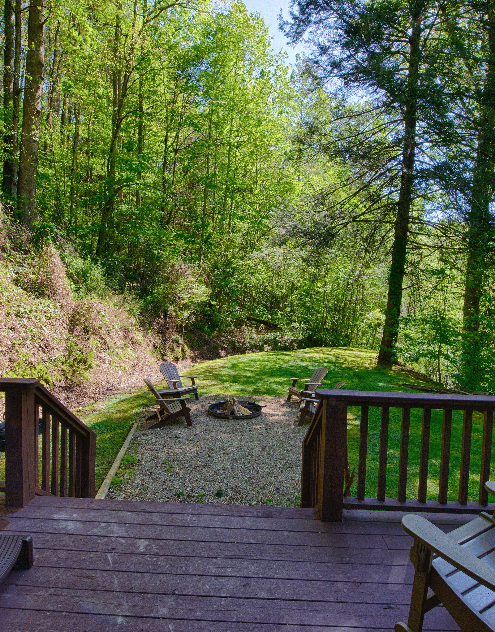 a wooden porch with an outdoor seating area and a Jacuzzi tub overlooking the beautiful greenery - Historic Tapoco Lodge