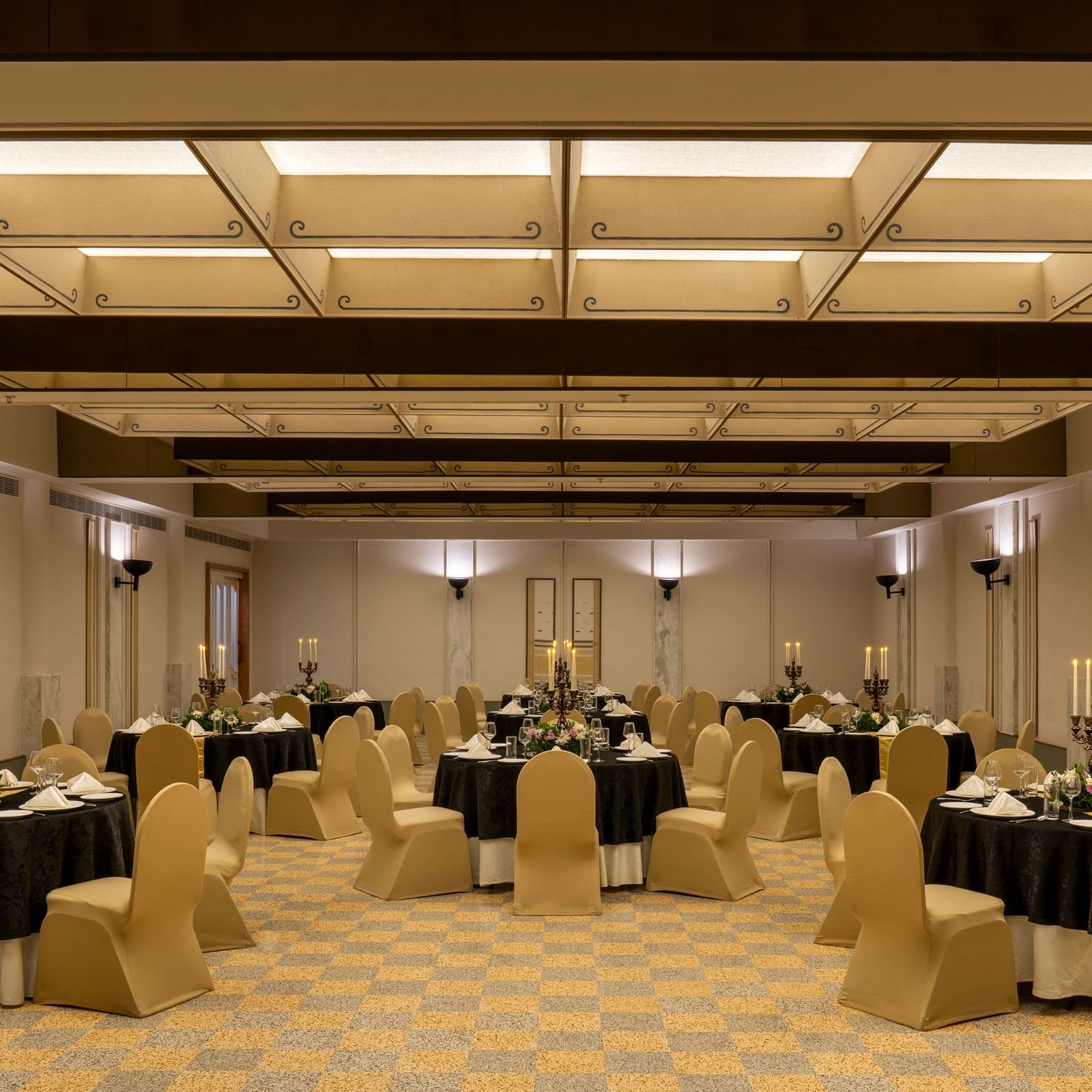  A banquet hall at Shilton International Kochi, set with numerous round tables and chairs, ready for an event.