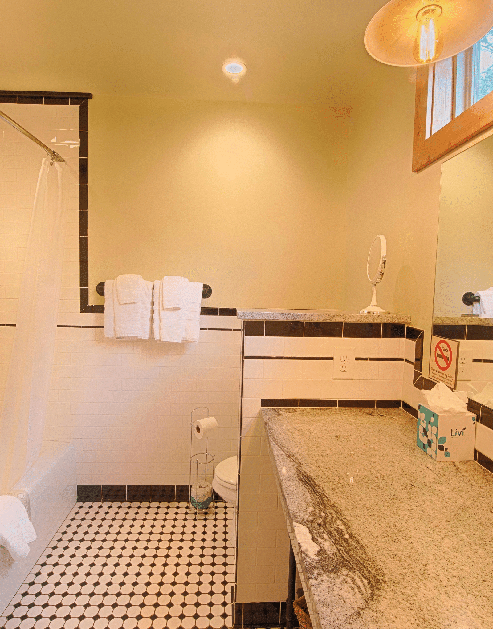 full view image of a bathroom with a bath tub with fresh linens hanging on the wall - Historic Tapoco Lodge