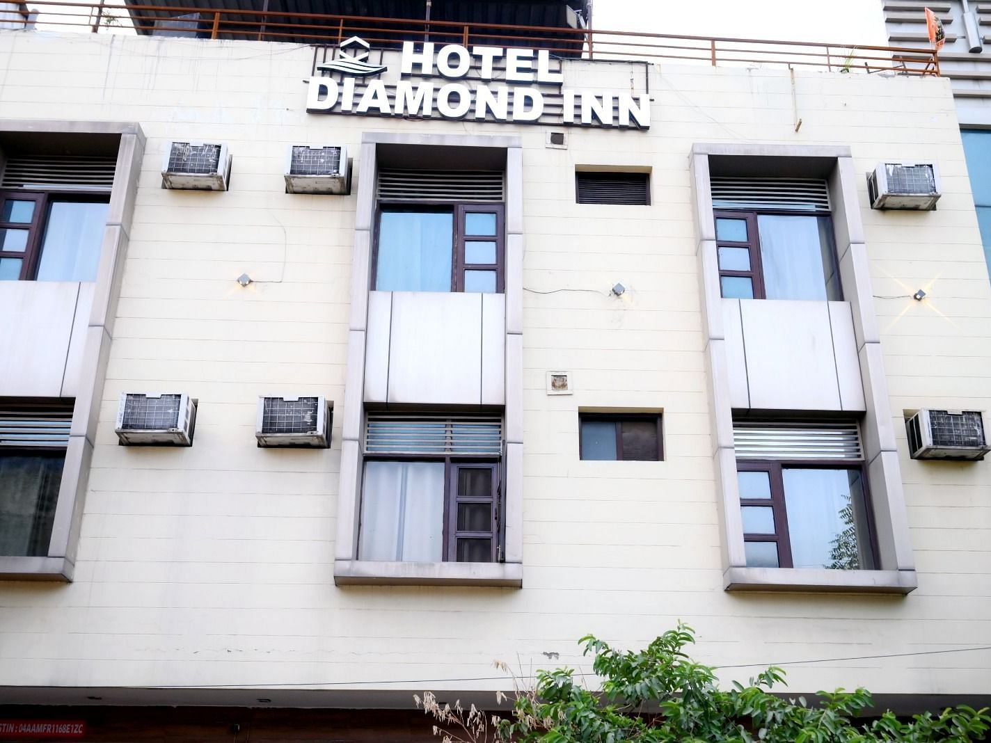 A well-lit exterior of Hotel Diamond Inn, showcasing the building façade with windows and air conditioning units - Hotel Diamond Inn, Chandigarh