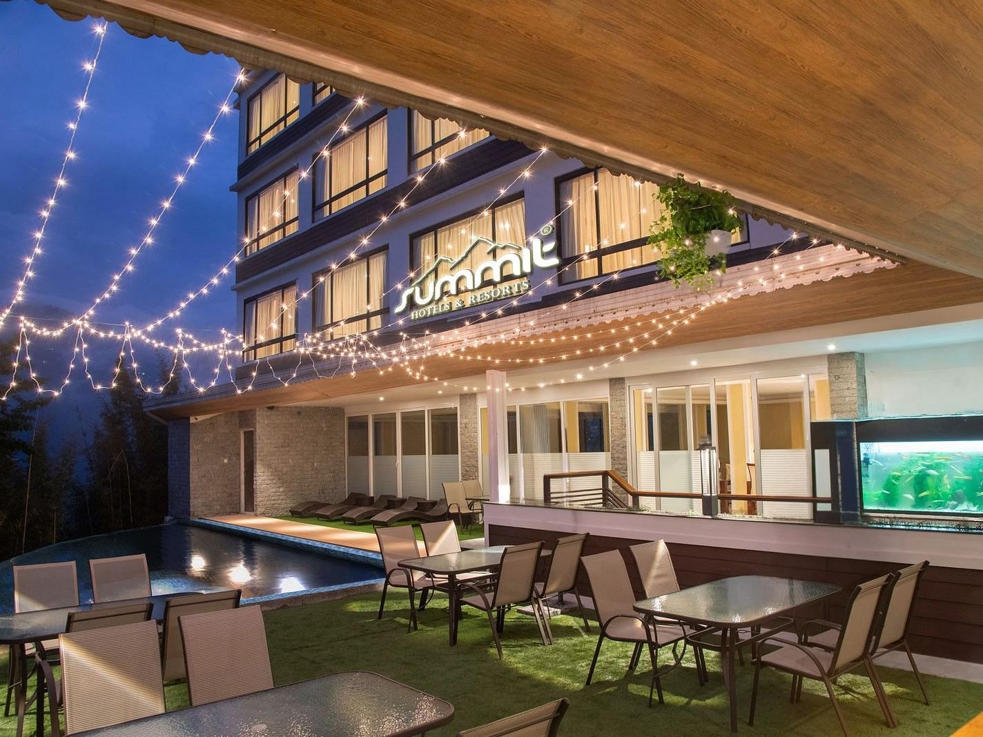 A pool side dining arrangement illuminated by hanging lights - Summit North Star, Gangtok