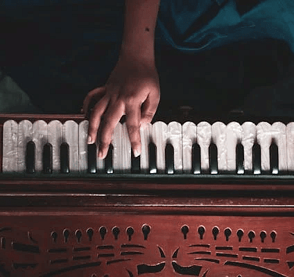 A top angle of a person playing the harmonium.