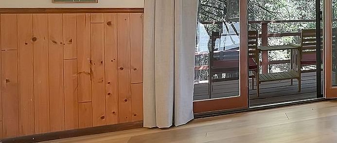 A room at Narrow Gauge Inn with a double bed and sliding doors opening up to a balcony with seating.