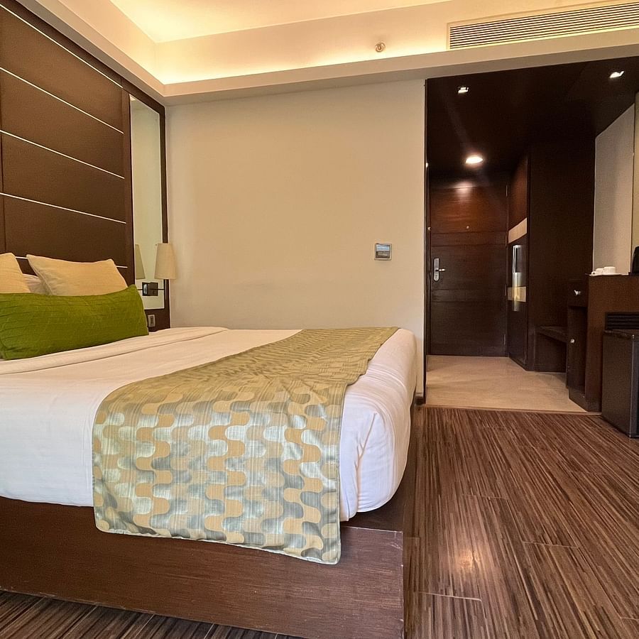 interior of a bedroom with king size bed and room amenities like wardrobe and teapoy - yuhi mansions2