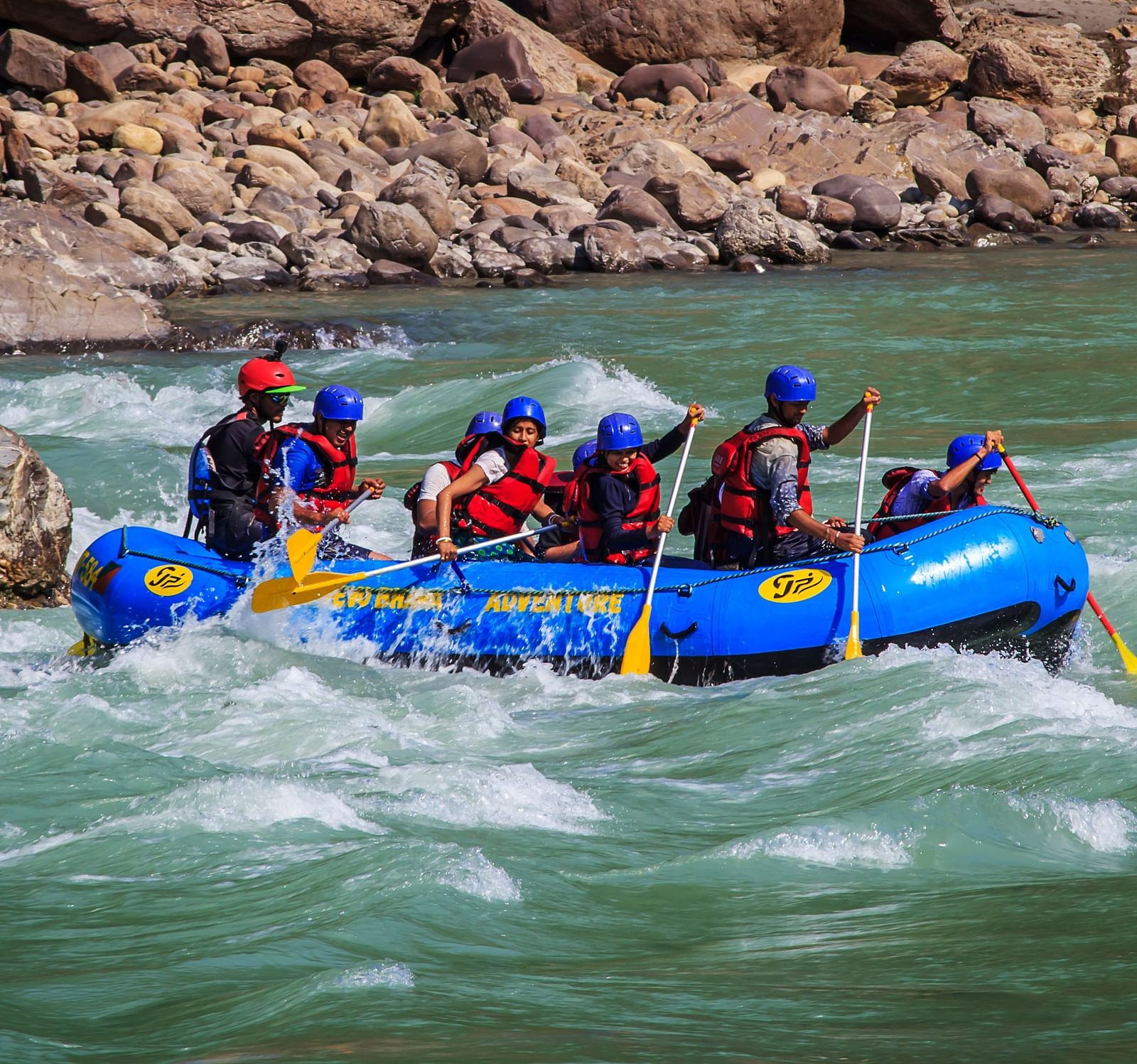 image of a group of tourists experiencing river rafting in the rapids in rishikesh