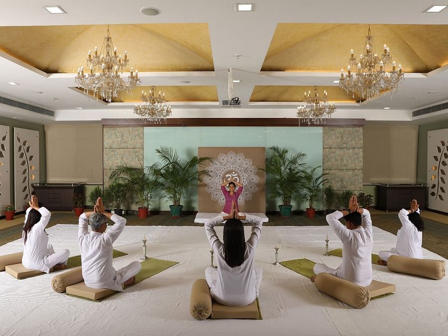 Heritage Village - image of people performing yoga movements led by a professional trainer
