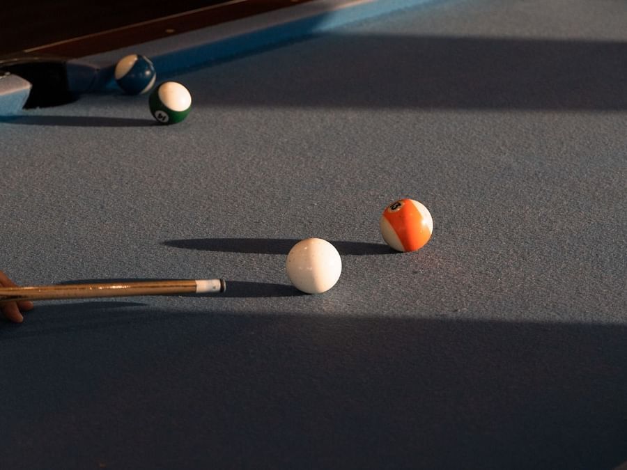 Close-up of a pool table with balls in mid-play.