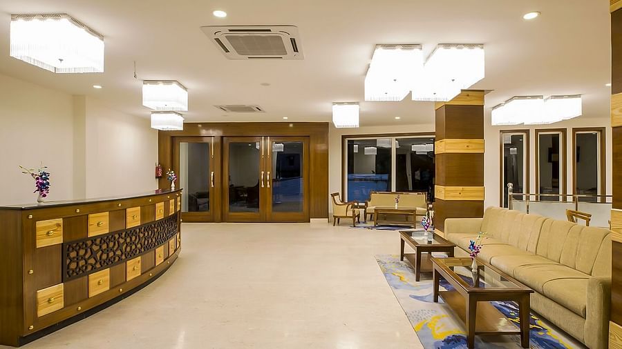 An empty lobby area at Regenta Inn DLS with the reception desk in a corner.