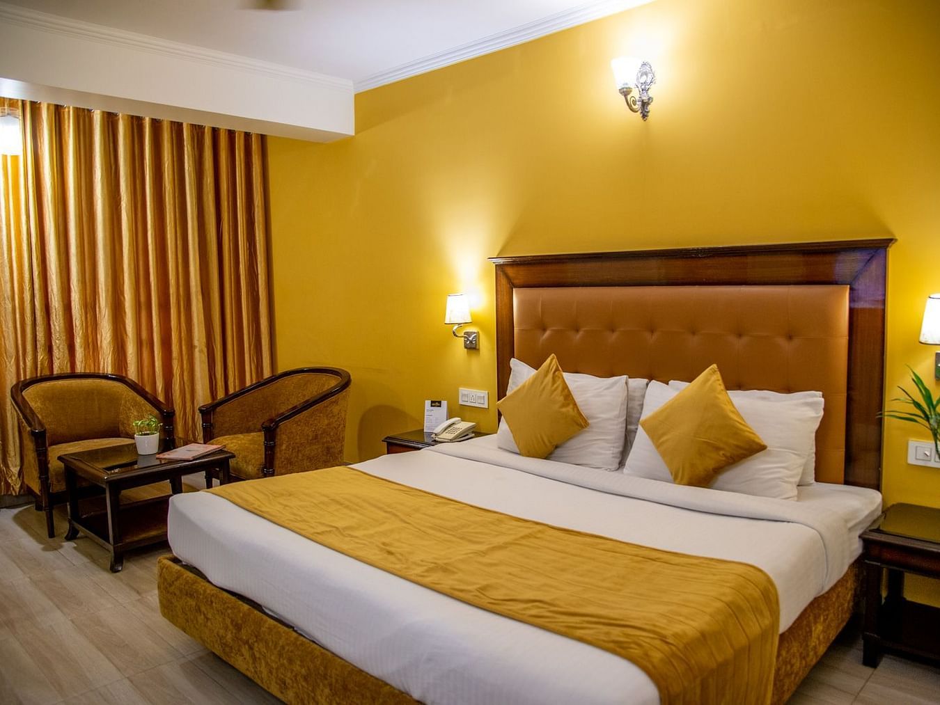 A room with a bed, 2 chairs and a coffee table | Sun Park Hotel & Banquet, Chandigarh - Zirakpuruxe Room-3