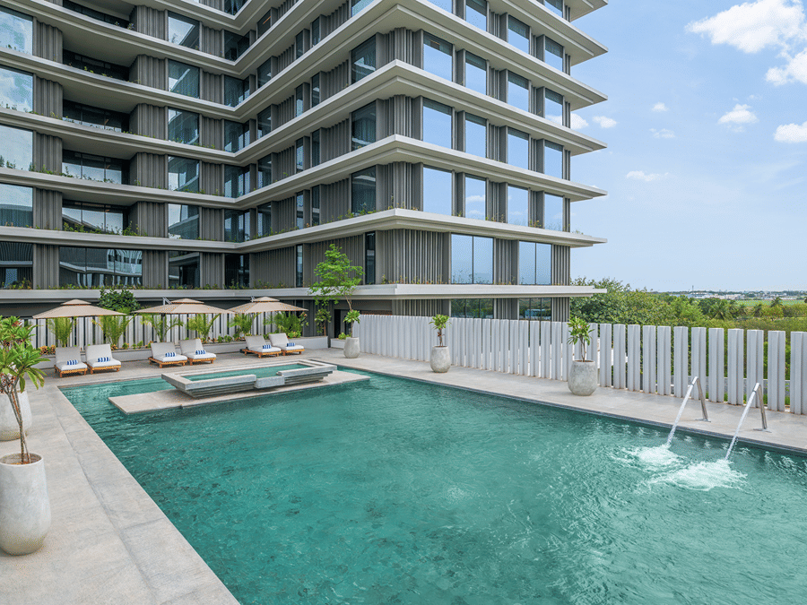 Rooftop swimming pool with loungers and a view of the building against the sky at The Residency Signature Madurai.