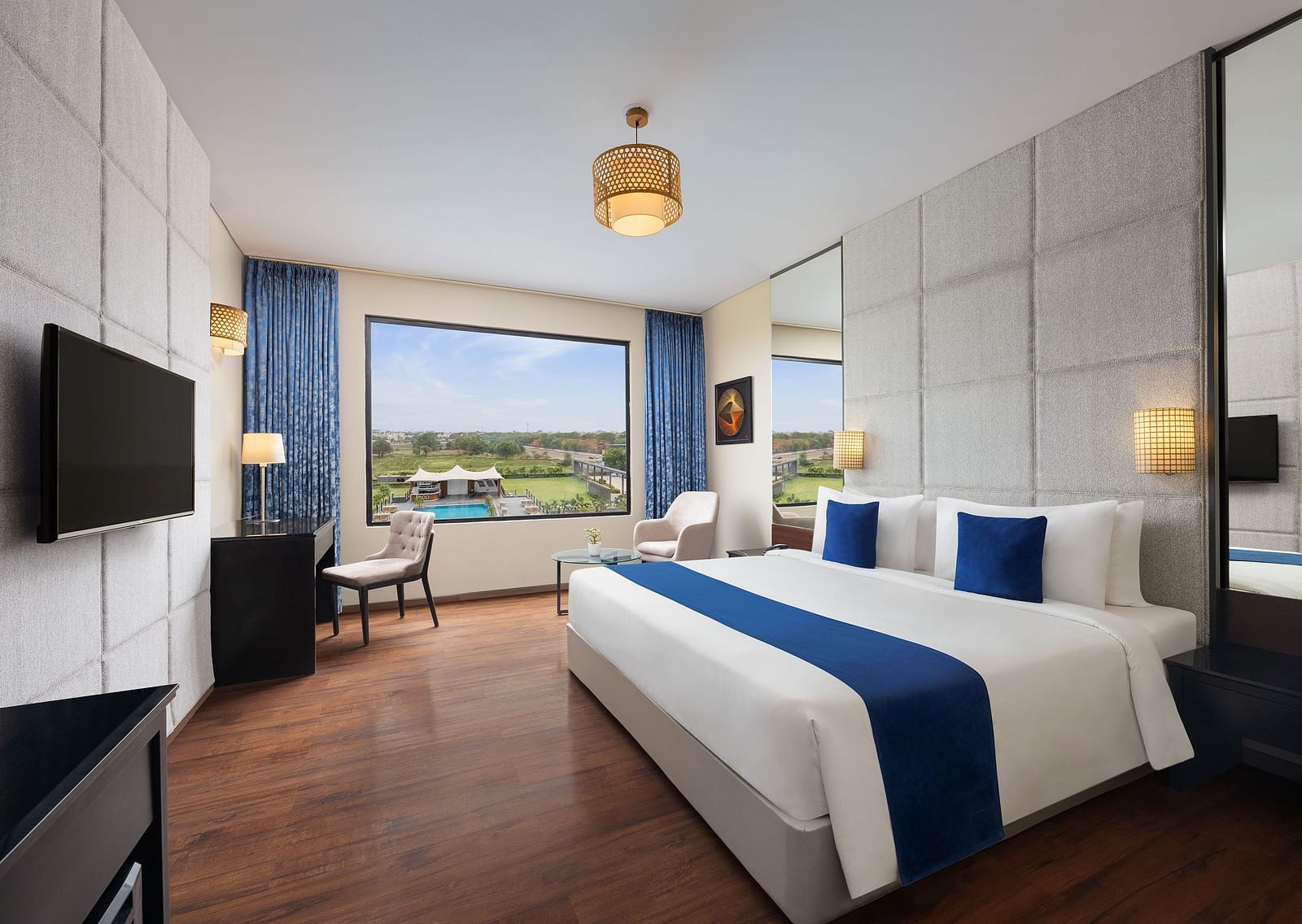 Premium Room at Essentia Luxury Hotel, Indore with a double bed, a television and work desk and chair
