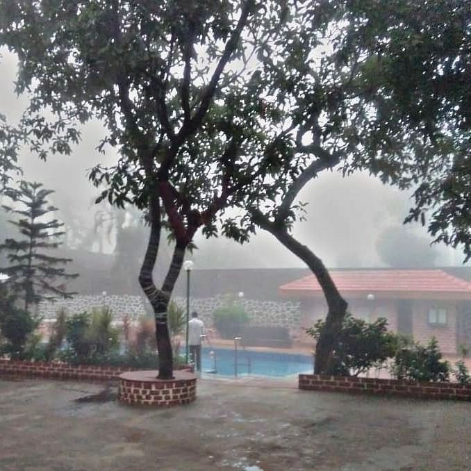 a mist-covered view of the swimming pool - Zara's Resort 1