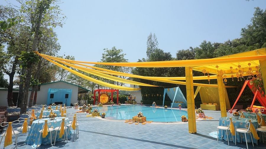 Colourful wedding decor by the poolside at Tattwa Corbett Resort, featuring vibrant drapes and elegant seating arrangements