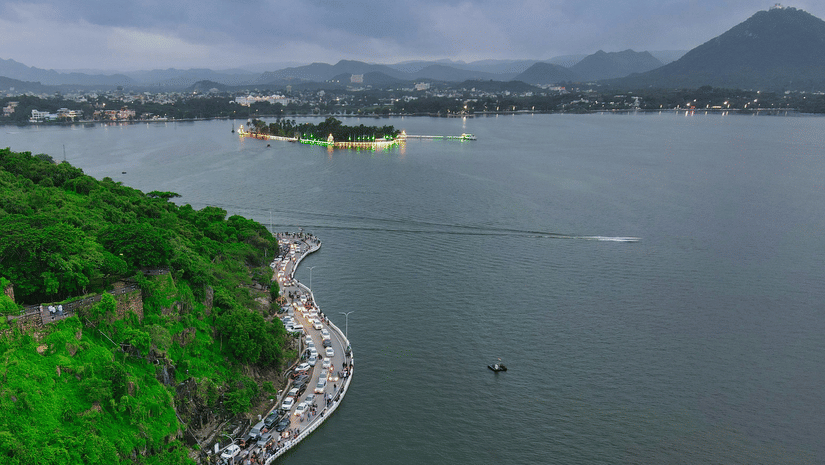 Aerial view of the curved, tree-lined promenade along the scenic Fateh Sagar Lake in Udaipur.