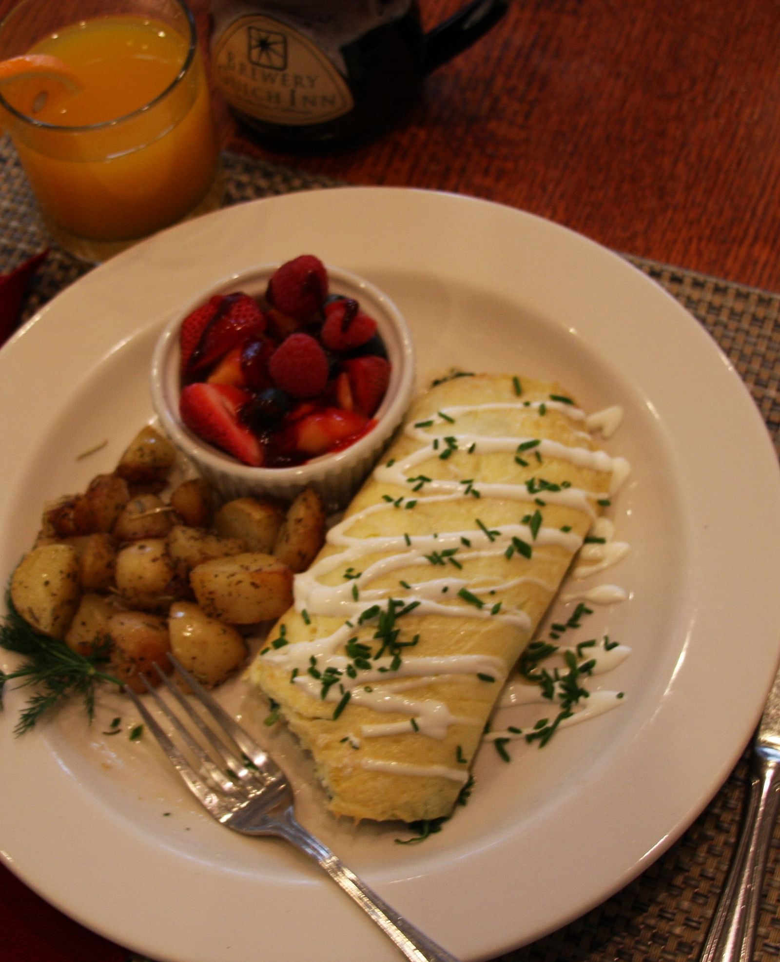 An omelette served with potatoes and strawberries - Brewery Gulch Inn & Spa