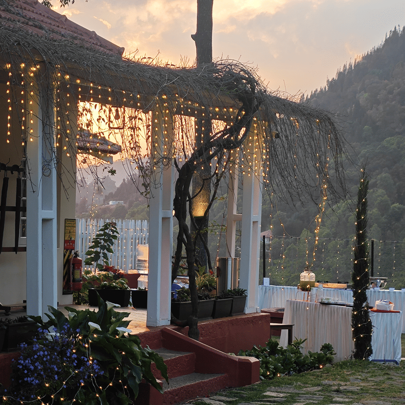 Outdoor wedding reception area at dusk with string lights and a covered porch in Coonoor - Ibex Resort, Coonoor (Leewood).