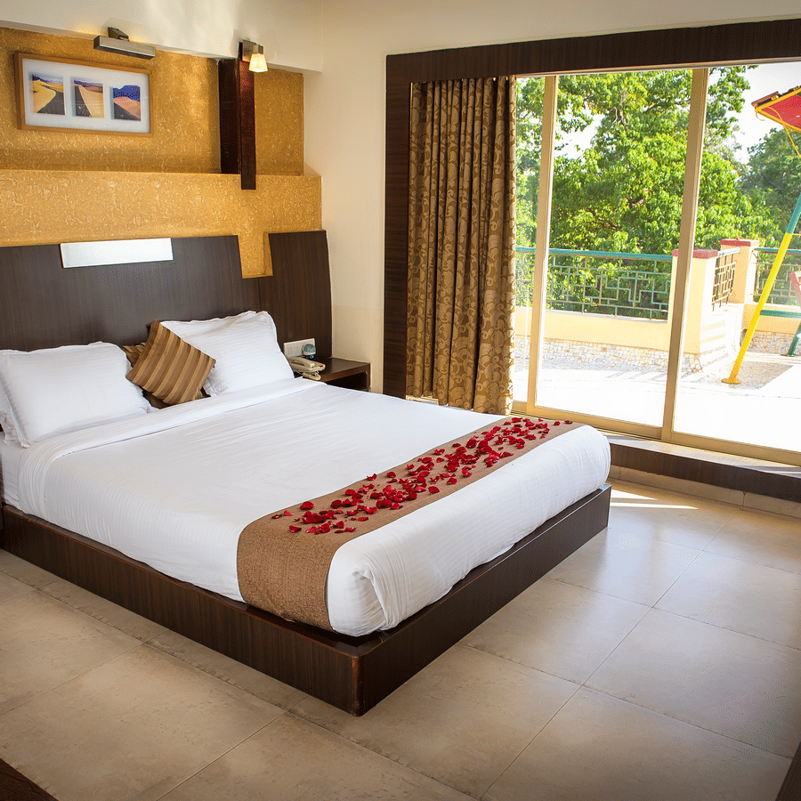 A view of the bed beside the window in Royal suite bedroom with glass doors leading to the terrace.