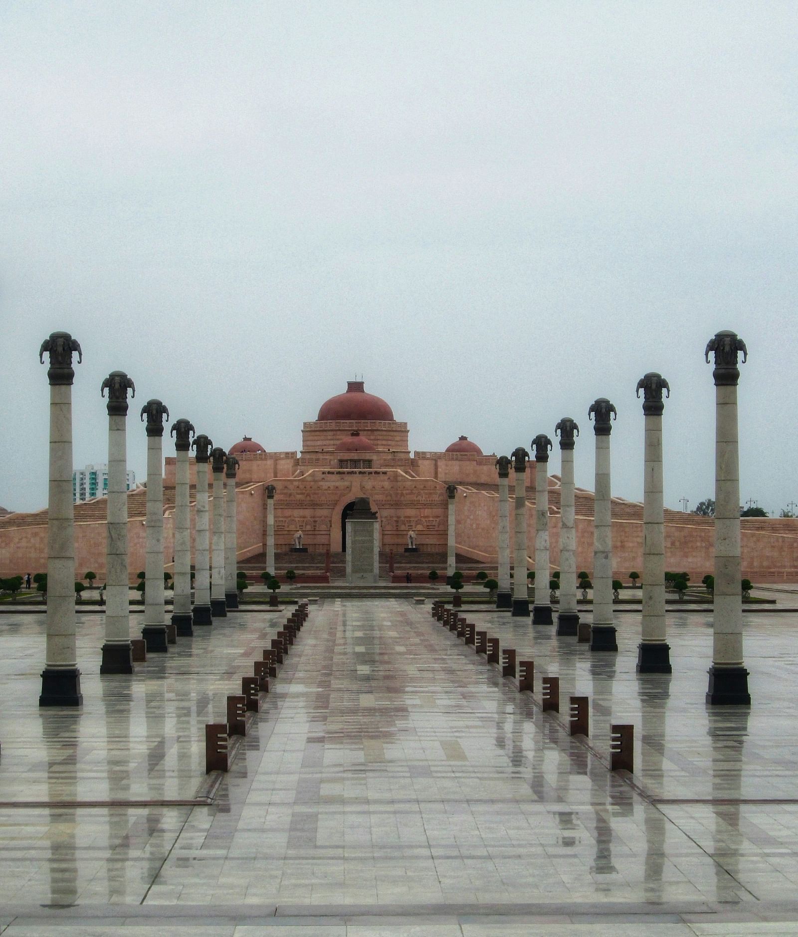 A spacious courtyard featuring elegant columns, with a prominent building visible in the background