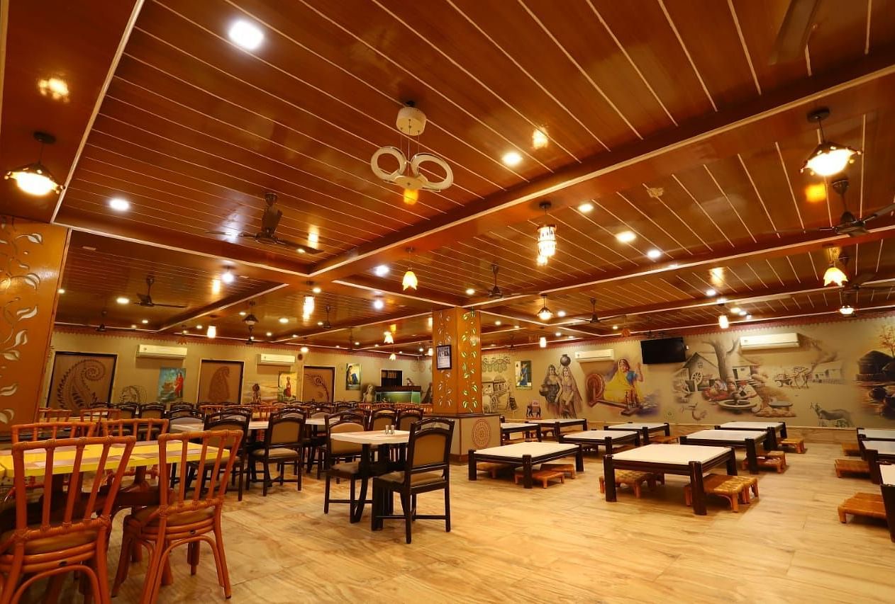 Restaurants fully furnished with wooden tables and chairs with warm lighting.