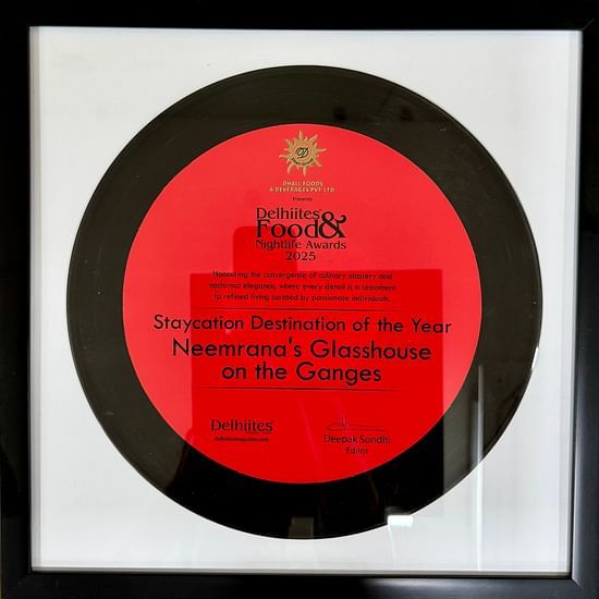Framed award plaque for 'Staycation Destination of the Year 2025' awarded to Neemrana's Glasshouse on the Ganges by Delhiites Food & Nightlife Awards.
