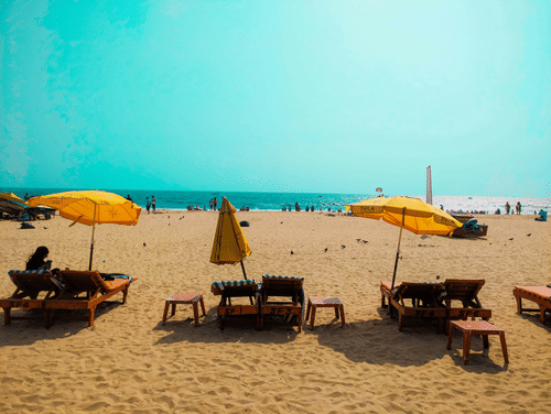 Vibrant yellow umbrellas and wooden loungers on the sandy shore.