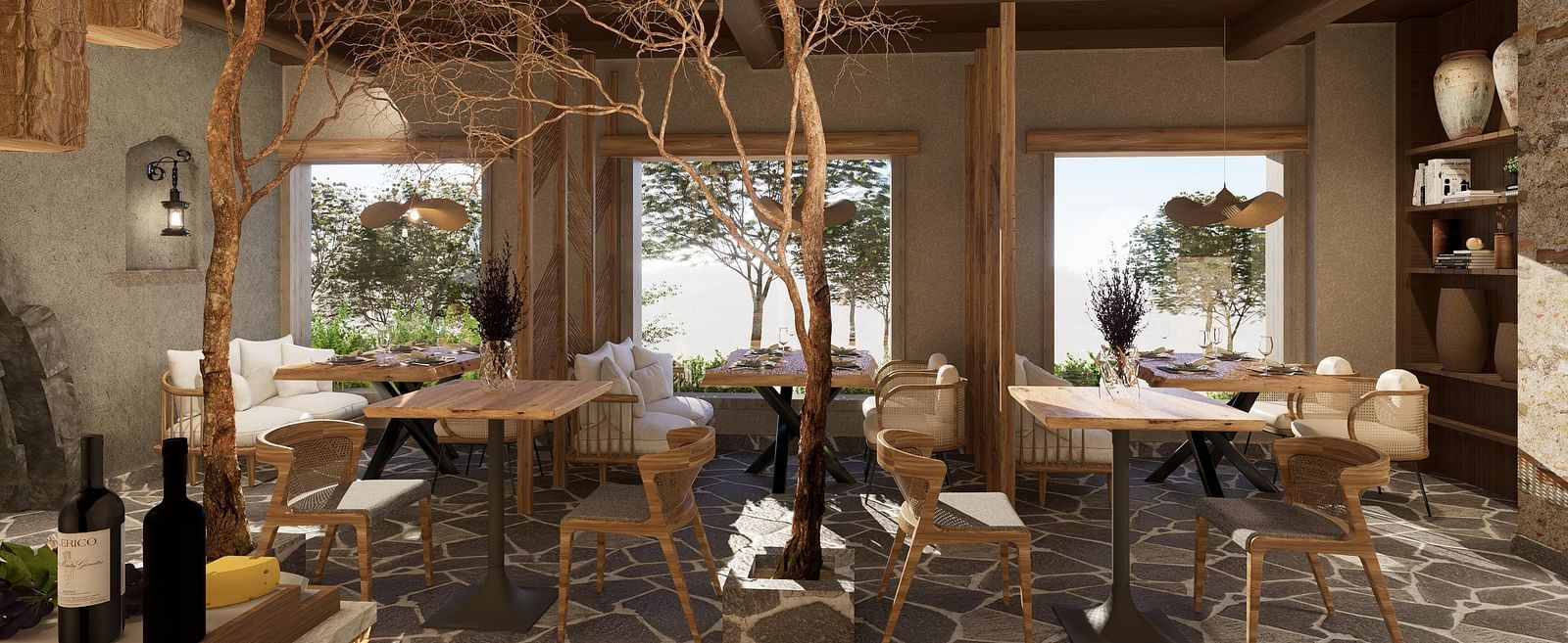 Side view of the restaurant at The Evren, Vagator, with arranged tables, chairs, and windows overlooking greenery.