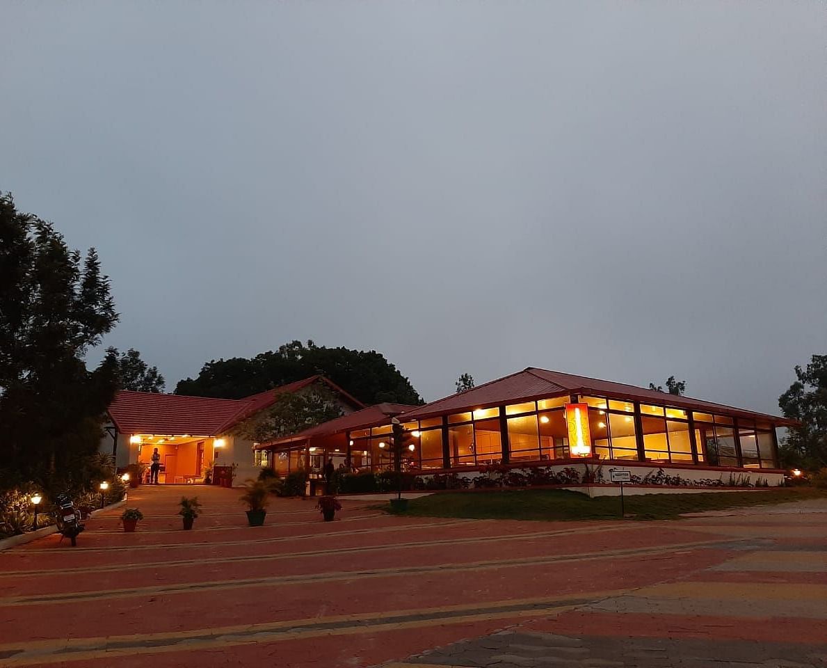 An evening view of Woodstock Resorts, Coorg highlighting the outdoor lighting and architecture.