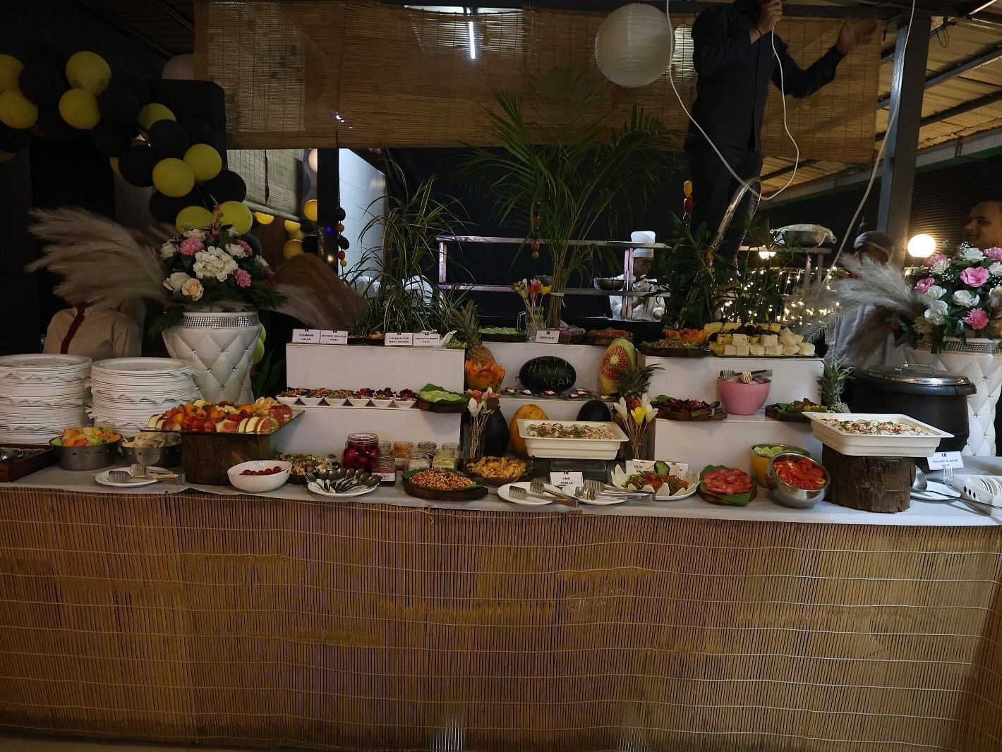 A lavish buffet spread is presented on a long table with various dishes and decorative elements - Lords Inn Vadodara